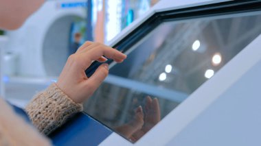 Şehir gösterisinde etkileşimli dokunmatik ekran kullanan kadın