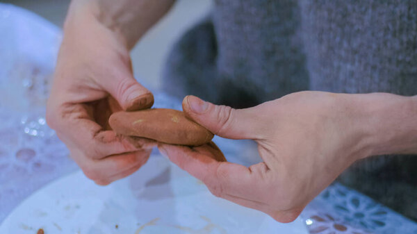 Professional male potter making mug in pottery workshop