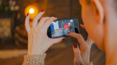 Artırılmış gerçeklik app ile Smartphone kullanarak ve mobilya odaya yerleştirerek kadın