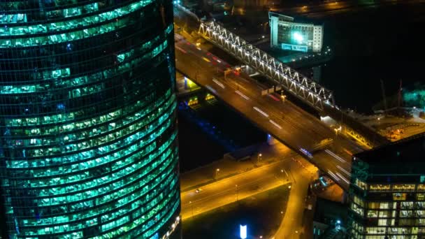 Timelapse: mrakodrap, rychle se pohybující automobilový provoz a teplé pouliční osvětlení v noci — Stock video