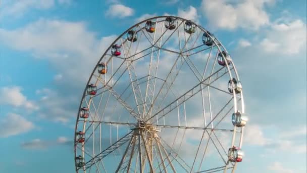 Timelapse de rotation de la roue ferris et le mouvement des nuages blancs, le coucher du soleil ciel nuageux — Video