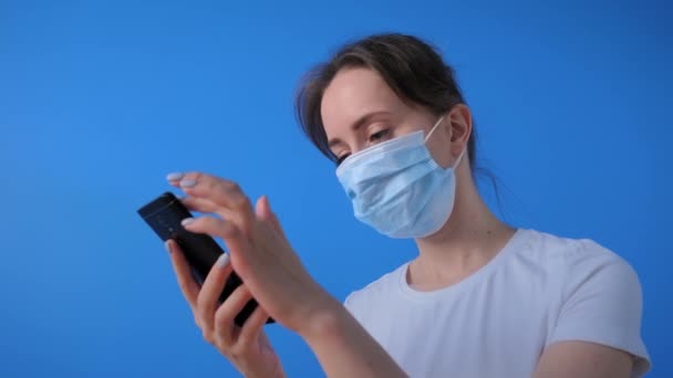 Donna che indossa maschera facciale, tenendo smartphone, utilizzando la funzione di riconoscimento vocale — Video Stock