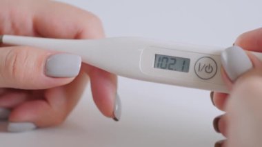 Ağır çekim: yüksek sıcaklıkta dijital medikal termometre tutan kadın