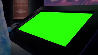 Yeşil ekran konsepti - boş etkileşimli yeşil ekran kioskuna bakan kadın
