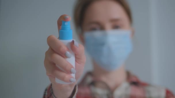 Медленное движение: женщина распыляет антисептик к камере - закрыть вид спереди — стоковое видео