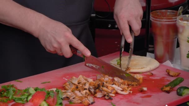 Медленное движение: шеф-повар режет куриное мясо на столе на фестивале уличной еды — стоковое видео