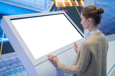 Sergide etkileşimli boş dokunmatik ekran kiosk kullanan kadın