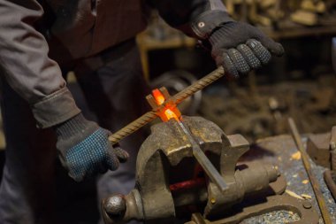 Demirci metalle çalışıyor.