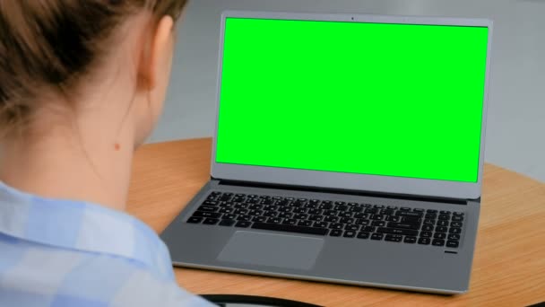 Mujer mirando el ordenador portátil con pantalla verde vacía — Vídeos de Stock