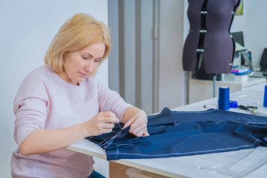 Profesyonel terzi, moda tasarımcısı dikiş stüdyosunda çalışıyor.