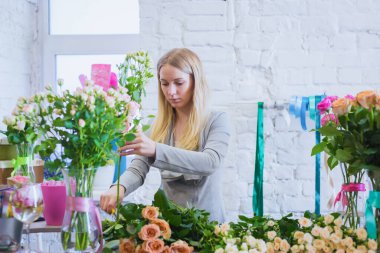 Stüdyoda çiçeklerle çalışan profesyonel bir çiçekçi.