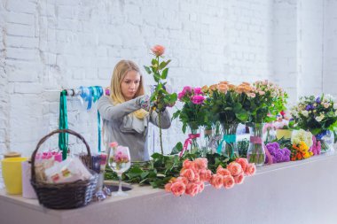 Stüdyoda çiçeklerle çalışan profesyonel bir çiçekçi.