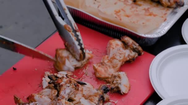 Koch schneidet Hühnerfleisch auf dem Tisch beim Street-Food-Festival - Nahsicht — Stockvideo