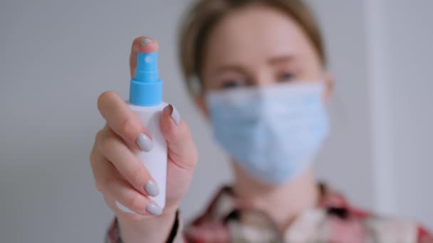 Slow motion: vrouw sprayen antiseptische richting camera thuis - close-up — Stockvideo