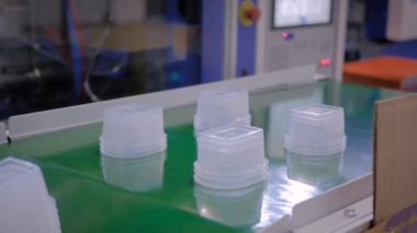 Plastik enjeksiyon makinesinin taşıyıcı bandındaki yiyecek kaplarını temizle