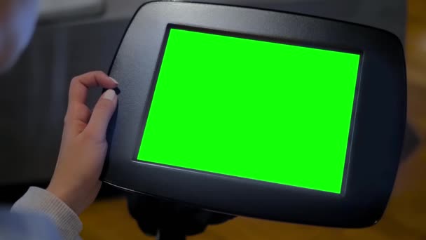 Kobieta patrząca na podłogę stojąca czarny tablet kiosk z pustym zielonym wyświetlaczem — Wideo stockowe
