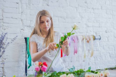 Stüdyoda çiçeklerle çalışan profesyonel bir çiçekçi.