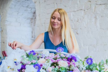 Çiçekçi, çiçekçide büyük bir çiçek sepeti yapıyor.