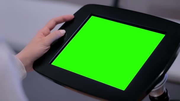 Жінка використовує стоїть на підлозі планшетний кіоск з порожнім зеленим дисплеєм крупним планом — стокове відео