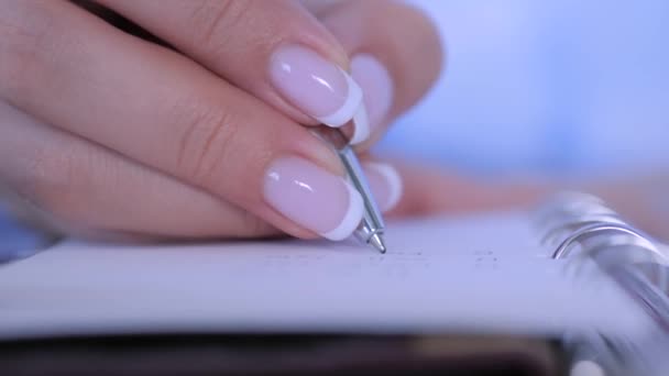 Close-up view - vrouw die schrijft om lijst te doen in notebook organisator - slow motion — Stockvideo