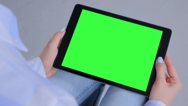 Mulher olhando para computador tablet preto com tela verde em branco - conceito de mockup — Vídeo de Stock