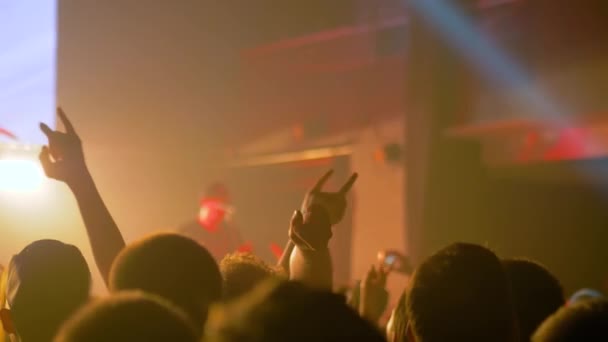 Ralenti : silhouettes de personnes faisant la fête lors d'un concert de rock devant la scène — Video