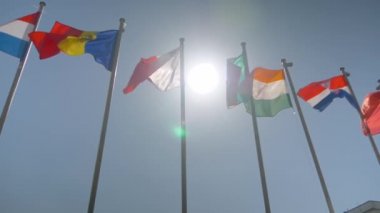 Süper yavaş çekim - rüzgarda dalgalanan renkli bayraklar - diplomasi konsepti