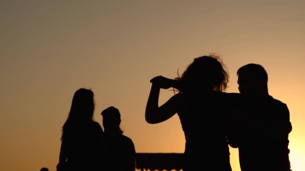 Siluetas de la gente aprendiendo a bailar en la ciudad al atardecer - super slow motion — Vídeo de stock