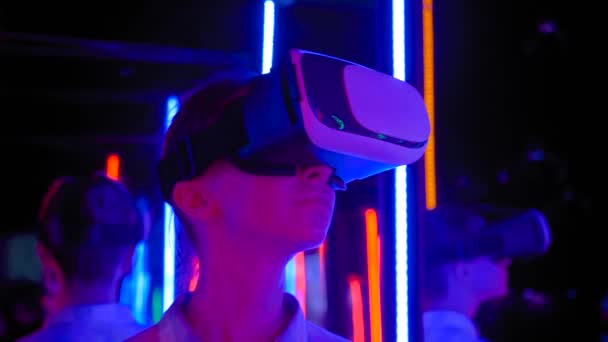 Movimento lento: mulher usando fones de ouvido de realidade virtual na exposição VR interativa — Vídeo de Stock