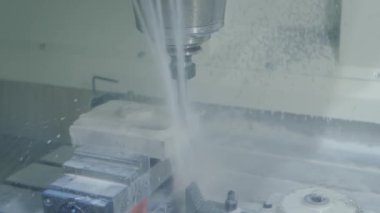 Fabrikada metal işçiliği kesen soğutma sistemi olan bir değirmen makinesi.