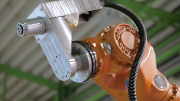 Оранжевый промышленный роботизированный манипулятор руками демонстрирует рабочий процесс — стоковое видео