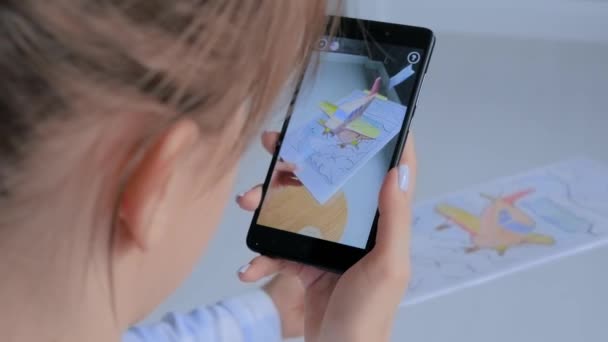 Kvinne som bruker smarttelefon med AR-applikasjon virtuell modell av flygende monoplan – stockvideo