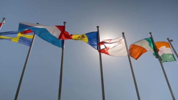 Färgglada flaggor fladdrar i vinden - super slow motion - diplomati koncept — Stockvideo