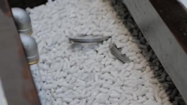 Aşındırıcı taşlarla metal işçilikleri parlatan bir vibratör makinesi.