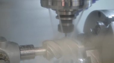 Fabrikada metal işçiliği kesen soğutma sistemi olan bir değirmen makinesi.