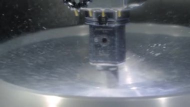 Fabrikada metal işçiliği kesen soğutma sistemi olan bir değirmen makinesi.