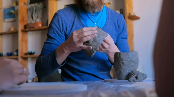 Man die laat zien hoe je klei mok te maken in aardewerk studio — Stockfoto