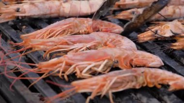 Yavaş çekim: Şef Brezilya usulü taze karides ızgara yapıyor.