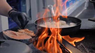 Yavaş çekim: Şef istiridye, somon, karides pişiriyor.