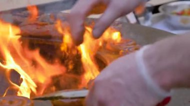 Yavaş çekim: şef ızgara taze sarmal domuz sosisi ve sıcak alevli Brezilya sosisi