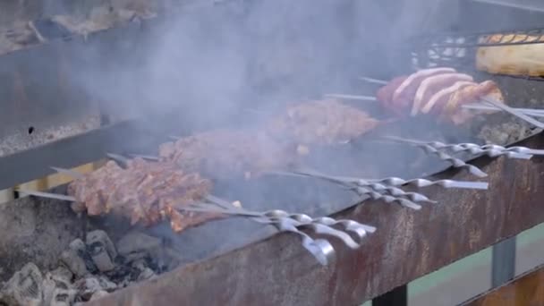 Lambat gerak: proses memanggang tulang rusuk babi pada tandu di festival makanan musim panas — Stok Video