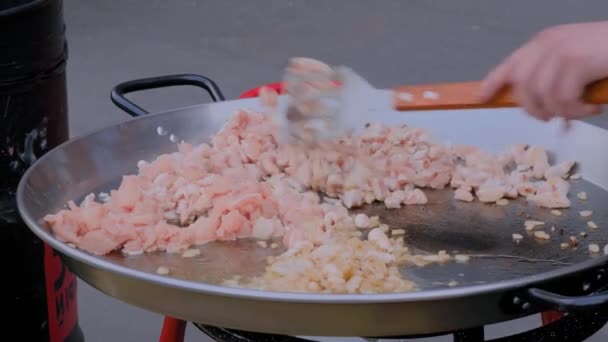 Szef kuchni gotowanie smażone kawałki mięsa kurczaka z cebulą w ogromny wok - widok z bliska — Wideo stockowe