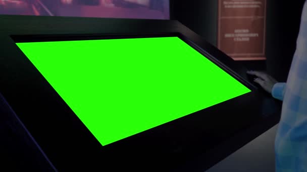 Mujer mirando en blanco quiosco pantalla verde en la exposición - concepto de pantalla verde — Vídeo de stock