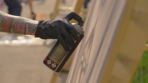 Hombre rociando pintura de lata en la superficie de madera en el festival de graffiti - cámara lenta — Vídeo de stock