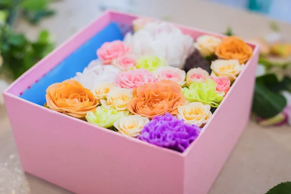 Colorful flowers in gift box on table at shop - close up