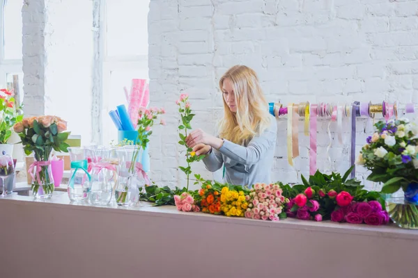 Professional floral artist working with flowers at studio