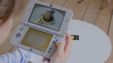 Oyun konsolu kullanan kadın oyuncu AR uygulaması ile Nintendo 3ds - görünümü kapat