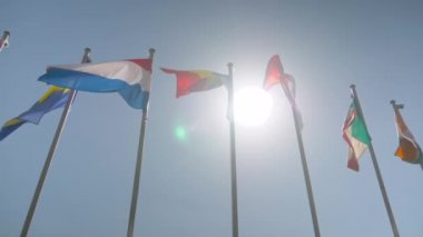 Süper yavaş çekim - rüzgarda dalgalanan renkli bayraklar - diplomasi konsepti