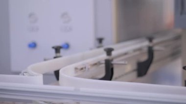 Sergide boş turuncu plastik bidonlar konveyör bandı üzerinde hareket ediyor