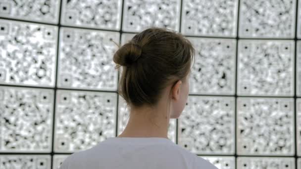 Портрет женщины у стены с qr-кодами на футуристической выставке — стоковое видео